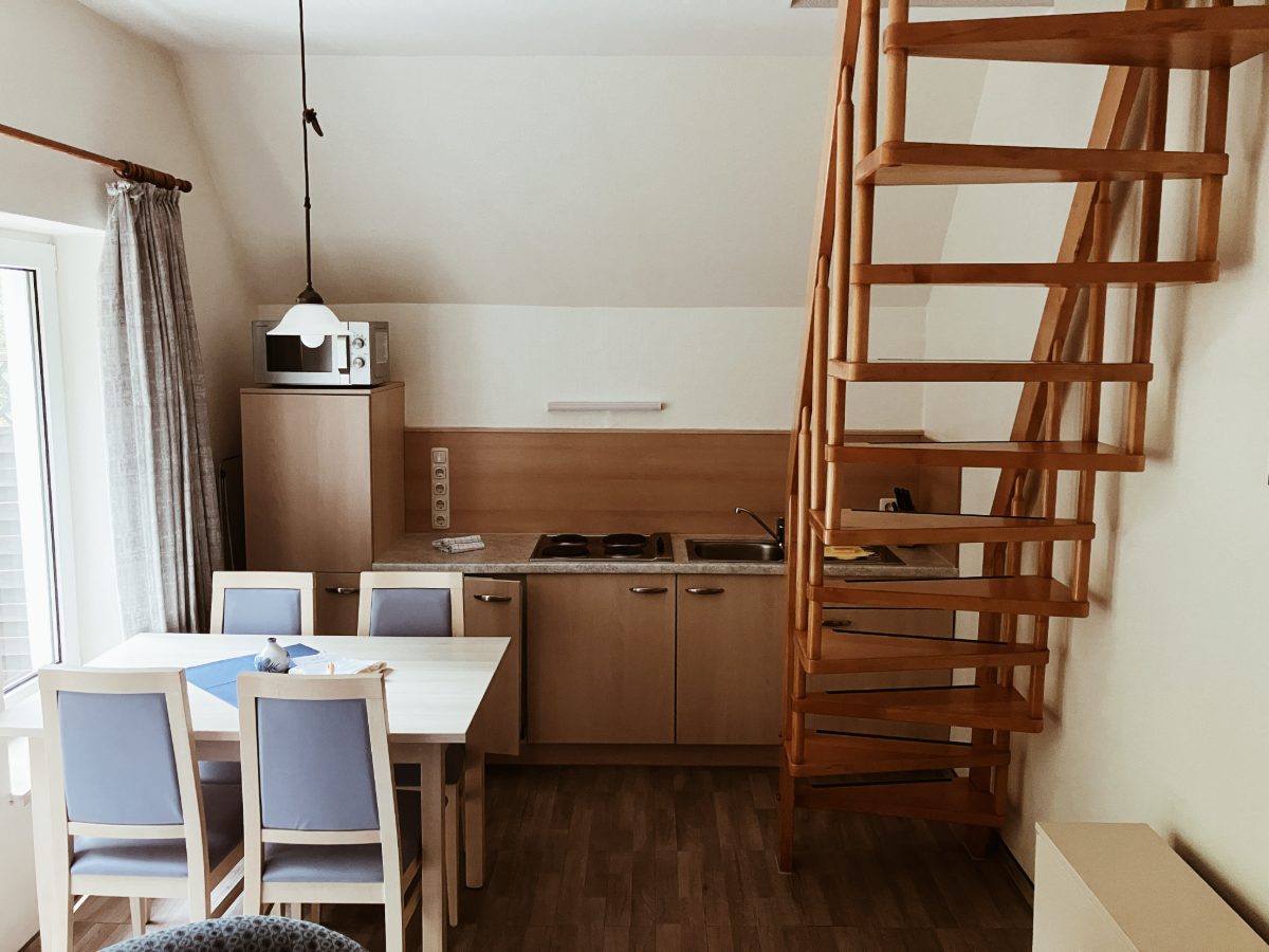 Essplatz mit Küchenzeile und Wendeltreppe ins Dachgeschoss