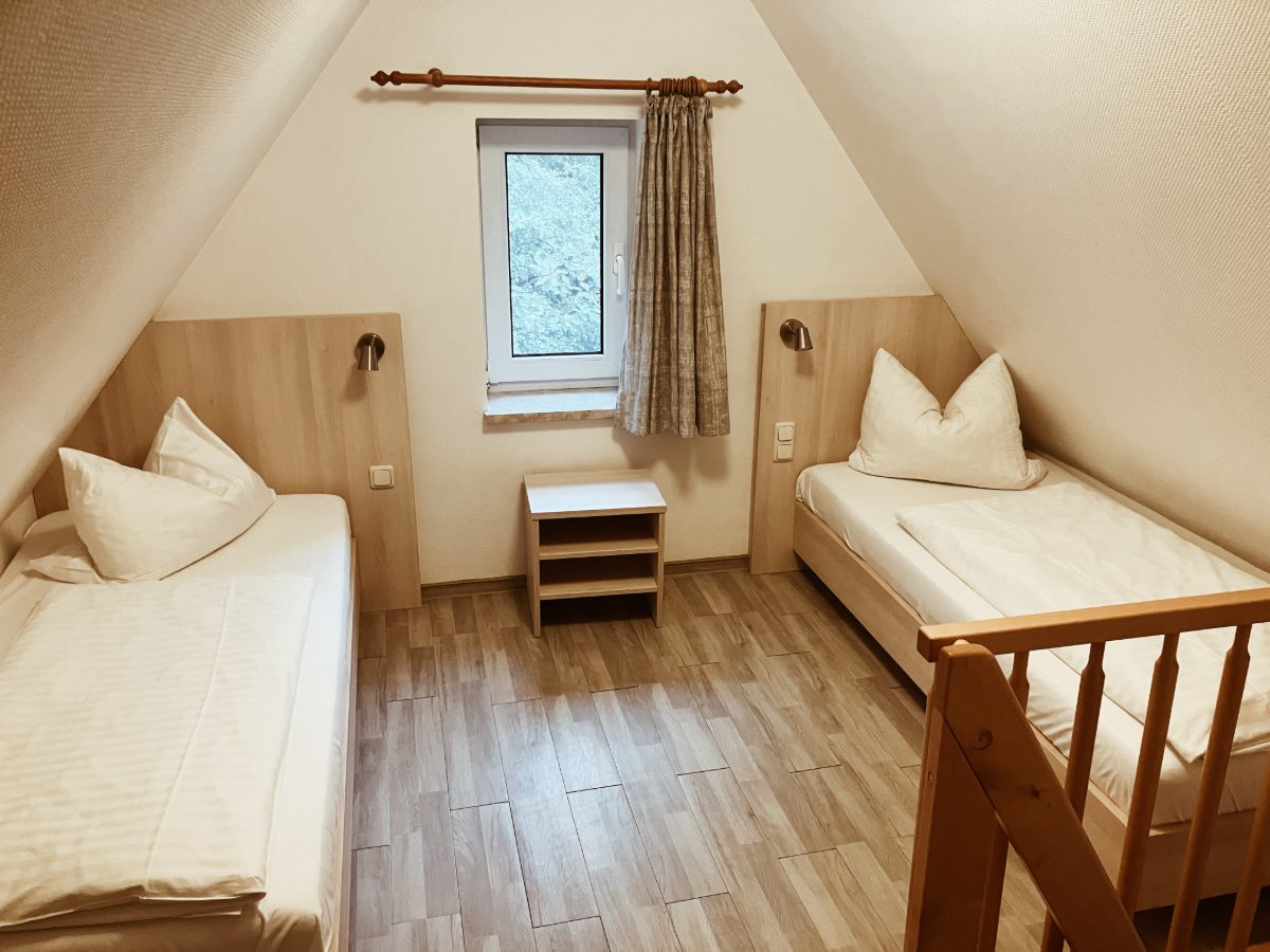 Schlafzimmer unter dem Dach mit zwei Betten und Fenster