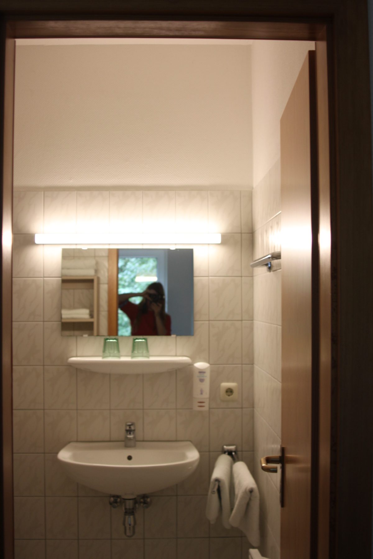 Bad mit Waschbecken, Spiegel und Handtüchern
